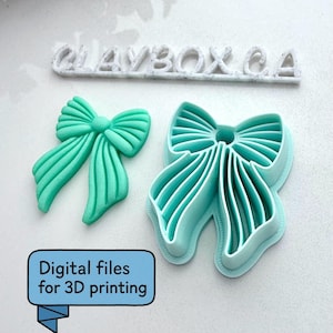 Puede incluir: Dos archivos de impresión 3D en forma de lazo turquesa y un lazo turquesa terminado. El texto "CLAYBOX CA" está encima de los lazos. Un rectángulo azul claro con el texto "Archivos digitales para impresión 3D" está en la esquina inferior izquierda.
