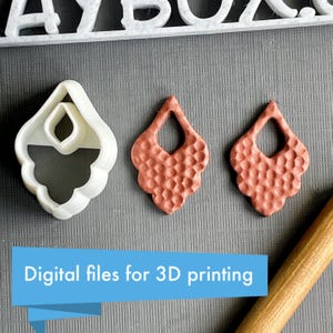 Könnte beinhalten: Das Bild zeigt einen weißen Ohrring-Ausstecher und zwei kupferfarbene Ohrringe. Die Ohrringe haben eine strukturierte Oberfläche und eine Tropfenform. Der Text "Digital files for 3D printing" befindet sich in einem blauen Banner.