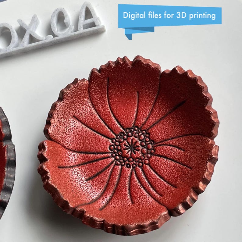 May include: A red, flower-shaped dish with a textured surface. The dish has a detailed center and petal design. The text "Digital files for 3D printing" is in a blue banner above the dish. The dish is likely a decorative item.