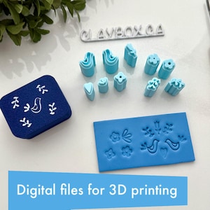 May include: A set of 3D printed polymer clay stamps featuring a variety of designs, including birds, flowers, and leaves. The stamps are blue and white and come in a variety of shapes and sizes. The stamps are designed for use with polymer clay, but can also be used with other crafting materials. The image also includes a blue and white stamp with a bird design and the text "CLAYBOX.CA".