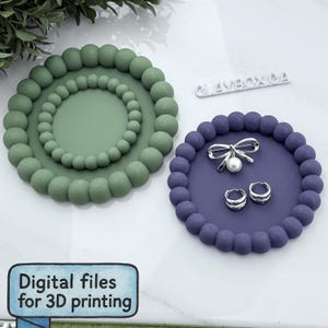 May include: Two decorative trays, one sage green and one purple, with a beaded edge design. The purple tray holds a silver bow pin with a pearl and silver hoop earrings. The text "Digital files for 3D printing" is visible.