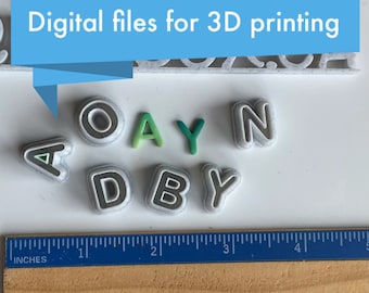 May include: A set of 3D printed letters spelling out the name "ADAYN" in white with a gray outline. The letters are arranged in a semi-circle on a white surface. A ruler is visible in the bottom of the image.