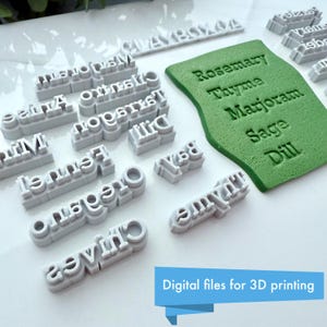 Puede incluir: Una colecci&oacute;n de sellos grises con nombres de hierbas impresos en 3D y una almohadilla verde con nombres de hierbas en relieve. Los sellos incluyen nombres como "Romero", "Tomillo" y "Eneldo". La imagen tambi&eacute;n incluye el texto "Archivos digitales para impresi&oacute;n 3D".