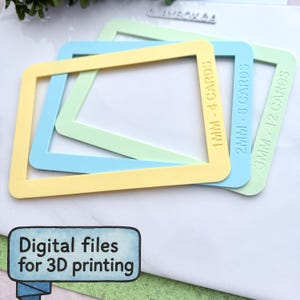 Op de afbeelding: Drie pastelkleurige, vierkante frames voor 3D-printen, gelabeld met kaartdiktes: 1mm-4 kaarten, 2mm-8 kaarten en 3mm-12 kaarten. De tekst "Digitale bestanden voor 3D-printen" staat onderaan. De frames zijn geel, blauw en groen.