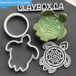 May include: A selection of turtle-themed items. Includes a green turtle figurine with a floral design, a white circular cookie cutter, and two white turtle-shaped cookie cutters. The text "Digital files for 3D printing" is visible.