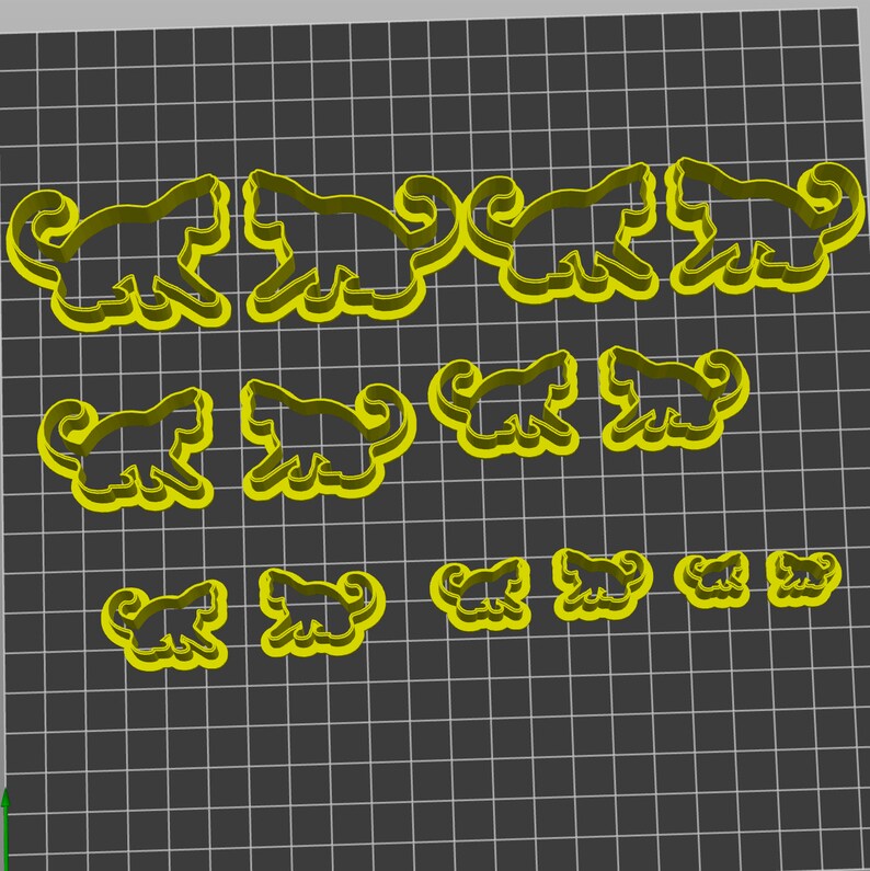 May include: A set of 12 yellow metal cookie cutters in the shape of a cat. The cutters are in various sizes, with the largest cutter being about 3 inches long and the smallest cutter being about 1 inch long.