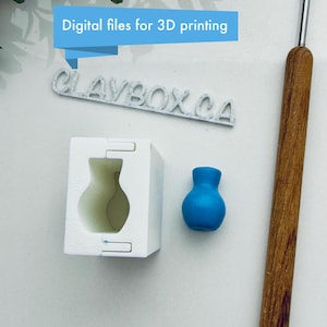 May include: A white 3D printed mold for a vase, a blue vase, and a wooden tool. The mold is open and the vase is visible inside. The text "CLAYBOX.CA" is visible in the image. The text "Digital files for 3D printing" is also visible in the image.