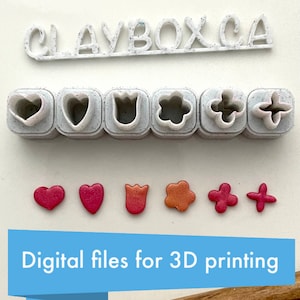 May include: A set of six 3D printed cookie cutters in the shape of a heart, tulip, flower, and two different cross shapes. The cutters are white and have a speckled texture. The image also shows six cookies in the same shapes, but in different colors: red, orange, and pink.