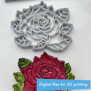 Puede incluir: Un modelo de rosa imprimible en 3D. El modelo se muestra en dos versiones: un modelo de plástico blanco y un modelo impreso en rojo y verde. El texto "Archivos digitales para impresión 3D" se muestra sobre un fondo azul.