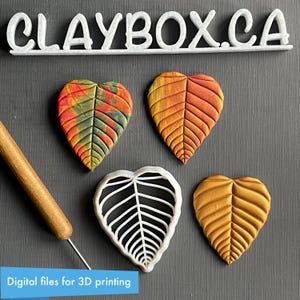 May include: Four leaf-shaped polymer clay molds, two with a textured design and two with a smooth design. The molds are white and are arranged on a dark gray surface. The text "CLAYBOX.CA" is visible at the top of the image.