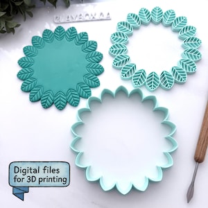 Op de afbeelding: Drie turquoise, bladvormige 3D-printbestanden. Eén is een effen cirkel met bladdetails rond de rand. Een andere is een ring van bladeren en de derde is een geschulpte cirkel. De tekst "Digital files for 3D printing" staat in een blauwe banner.