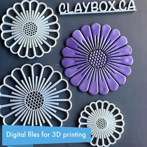 May include: Four white plastic flower-shaped cookie cutters, one large, one medium, one small, and one purple clay flower. The text "CLAYBOX.CA" is visible at the top of the image. The text "Digital files for 3D printing" is visible at the bottom of the image.