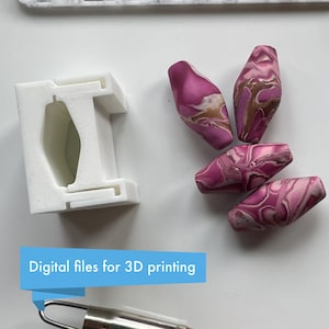 May include: A white 3D-printed object and four pink and brown marbled beads are displayed on a white surface. The text "Digital files for 3D printing" is in a blue banner. A silver tool is at the bottom.