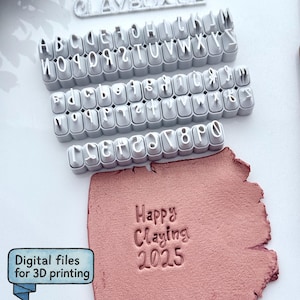 Pode incluir: Um conjunto de carimbos cinzentos de alfabeto e números ao lado de um pedaço de argila rosa com as palavras "Happy Claying 2025" estampadas. A imagem também inclui o texto "Digital files for 3D printing".