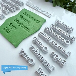 Puede incluir: Una colecci&oacute;n de sellos de etiquetas de hierbas grises impresos en 3D y un sello verde texturizado con nombres de hierbas. El texto "Rosemary, Thyme, Marjoram, Sage, Dill" es visible. El texto "Digital files for 3D printing" tambi&eacute;n es visible.