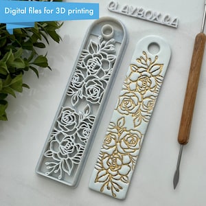 Puede incluir: Dos marcapáginas de arcilla polimérica blanca con un diseño floral. Un marcapáginas es un molde con un diseño floral en relieve, y el otro marcapáginas tiene un diseño floral dorado. El texto "CLAYBOX.CA" es visible en el fondo.