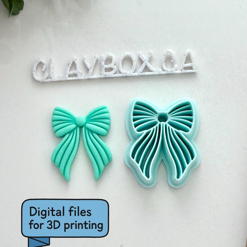 Op de afbeelding: Twee turquoise strikvormige objecten, &eacute;&eacute;n effen en &eacute;&eacute;n met een uitgesneden ontwerp, naast de tekst "CLAYBOX CA". Hieronder staat in een blauw kader "Digitale bestanden voor 3D-printen".