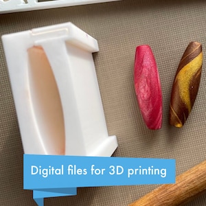 Puede incluir: Un molde blanco impreso en 3D para hacer cuentas. Se muestran dos cuentas junto al molde, una es roja con remolinos blancos y la otra es marrón con remolinos dorados. "Archivos digitales para impresión 3D" está escrito en una pancarta azul.