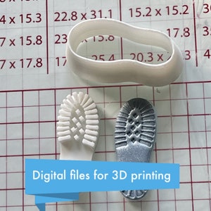 May include: Two 3D printed shoe soles, one white and one silver, on a gridded surface. The text "Digital files for 3D printing" is visible below the soles.