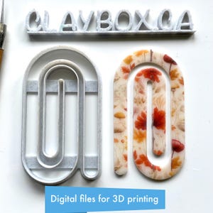 May include: Two arch-shaped clay cutters, one gray and one with a floral pattern of red, orange, and beige leaves and mushrooms. The text "CLAYBOX CA" is above the cutters. Below, the text reads "Digital files for 3D printing".