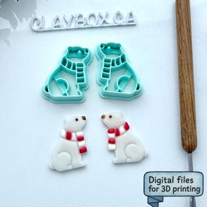 May include: A collection of polar bear-themed items. Two teal-colored plastic cookie cutters shaped like polar bears wearing scarves, and two white polar bear figurines with red and white scarves. The text "CLAYBOX CA" and "Digital files for 3D printing" are visible.