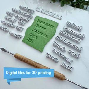 Puede incluir: Un conjunto de sellos grises con nombres de hierbas impresos en 3D, una pieza de arcilla verde con nombres de hierbas en relieve y una herramienta con mango de madera. El texto "Digital files for 3D printing" se muestra en una pancarta azul.
