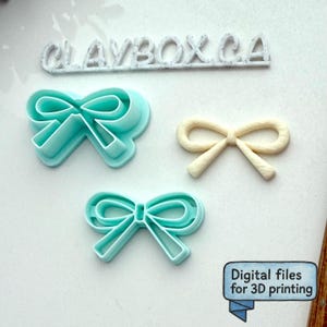 Op de afbeelding: Een verzameling strikvormige 3D-printbestanden en een afgewerkte strik. De bestanden zijn lichtblauw en de afgewerkte strik is gebroken wit. De tekst "CLAYBOX.CA" staat boven de strikken en de tekst "Digitale bestanden voor 3D-printen" staat in een blauwe doos.