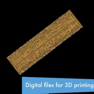 May include: A close-up of a brown rectangular surface with black hieroglyphics carved into it. The surface is angled and appears to be made of stone.