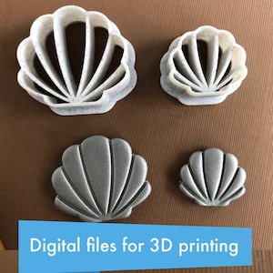 以下が含まれることがあります： 2つのサイズで3Dプリントされた貝殻のクッキーカッターが4つあります。大きなカッターは白地に斑点模様で、小さなカッターはメタリックシルバーです。