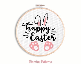 May include: White embroidery hoop with a cross-stitch design of a bunny with pink ears and paws. The design says "Happy Easter" in black cursive lettering.