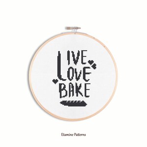 May include: A black and white cross-stitch embroidery hoop with the text "Live Love Bake" and a small loaf of bread design.