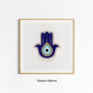 May include: A blue and gold hamsa hand with a blue evil eye in the center. The hamsa is a symbol of protection and good luck.
