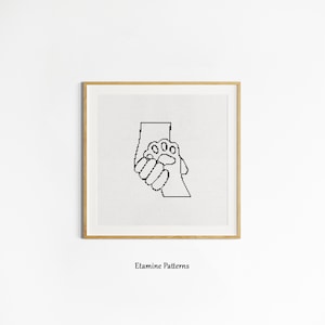 May include: Black and white line art illustration of a human hand holding a paw print. The image is in a simple, minimalist style and is suitable for cross-stitch or embroidery projects.