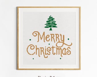 May include: A framed cross-stitch design with the words "Merry Christmas" in gold and a green Christmas tree. The design is on a white background and framed in a light brown wooden frame. The text "Etamine Patterns" is at the bottom.