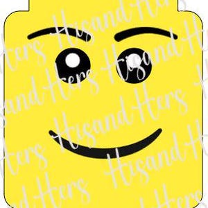 May include: A yellow Lego brick with a smiling face. The face has black eyebrows, black eyes, and a black smile.