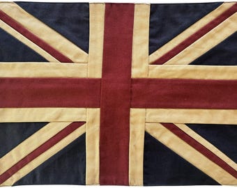 May include: A vintage-style Union Jack flag with a distressed look. The flag is made of a thick, woven fabric and has a faded, worn appearance. The colors are red, white, and blue.