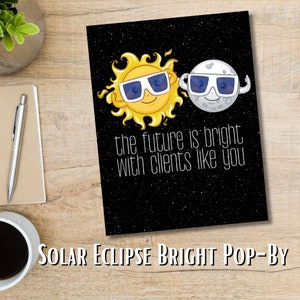 Puede incluir: Una tarjeta negra con un sol amarillo y una luna blanca que llevan gafas de sol. El sol y la luna sonríen y tienen los brazos levantados en el aire. El texto en la tarjeta dice "the future is bright with clients like you".