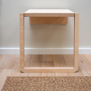 Front view of light birch folding wall chair open for use, minimalist Scandinavian furniture design.