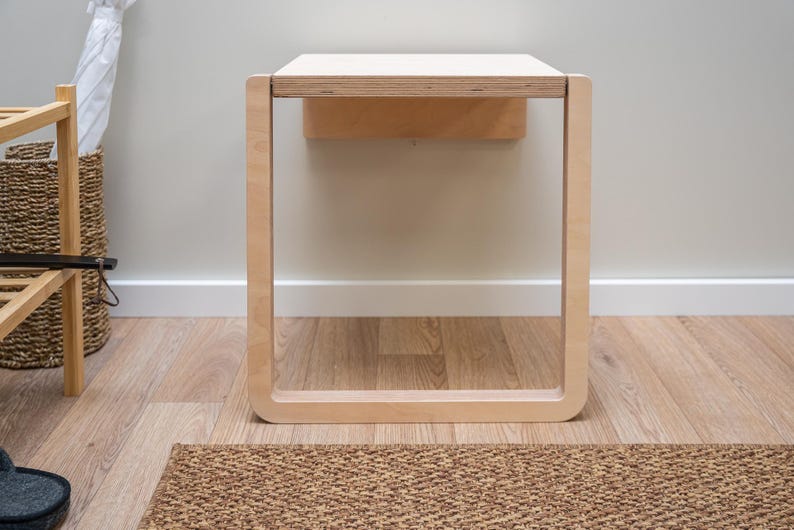 Front view of light birch folding wall chair open for use, minimalist Scandinavian furniture design.