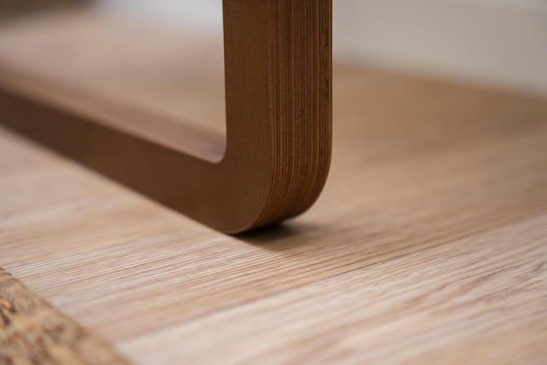 Edge view of dark birch plywood folding wall chair showing smooth rounded join and sturdy design.