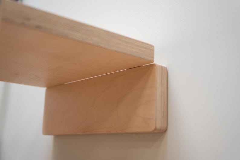 Close-up of folding mechanism and clean joint detail on minimalist birch plywood wall chair.