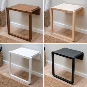 Puede incluir: Cuatro estantes flotantes montados en la pared en diferentes colores: marr&oacute;n, madera natural, blanco y negro. Cada estante tiene una parte superior rectangular y un marco cuadrado abierto. Los estantes est&aacute;n montados en una pared blanca.