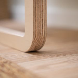 Side view of Scandinavian-style light birch folding wall chair made from durable plywood for space-saving interiors.