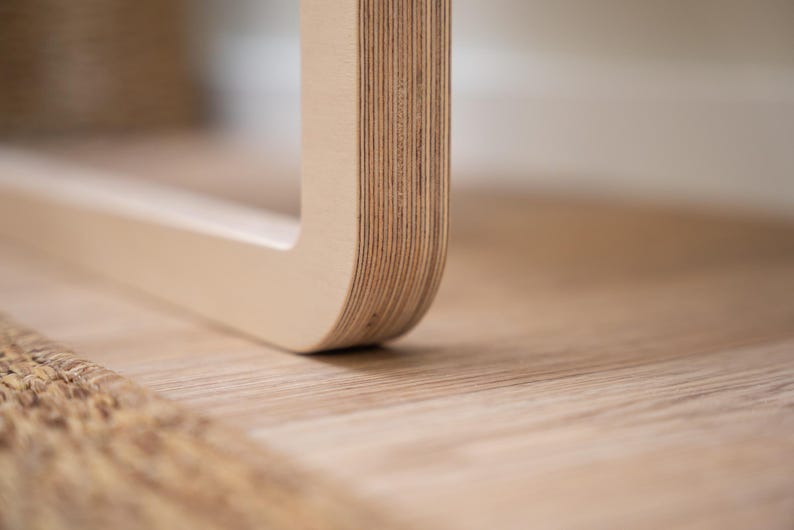 Side view of Scandinavian-style light birch folding wall chair made from durable plywood for space-saving interiors.