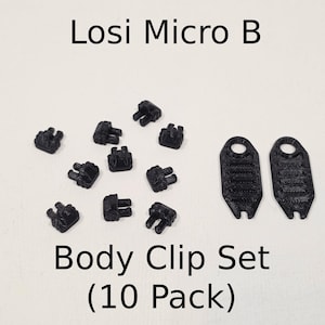 May include: A set of ten black plastic body clips for a Losi Micro B remote control vehicle. The set includes eight small U-shaped clips and two larger, flat, rectangular pull-tab clips. The text Losi Micro B Body Clip Set (10 Pack) is visible.