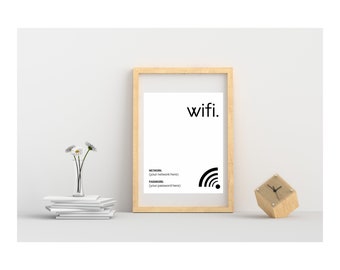 May include: A framed print with the word "wifi" in black text and a wifi symbol in black. The frame is light brown wood. The print is on a white background. There is a small wooden clock and a vase with white flowers on a white surface.
