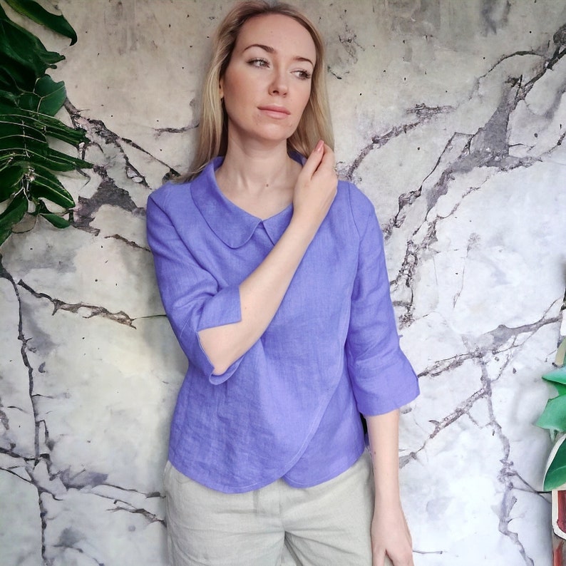 May include: A lavender linen blouse with a peter pan collar and 3/4 sleeves.