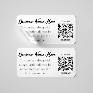 Op de afbeelding: Twee witte rechthoekige stickers met zwarte tekst en een zwart-witte QR-code. De tekst op de bovenste sticker luidt "Business Name Here" en "Custom text along with (optional) can be here, under the iness name." De tekst op de onderste sticker luidt "Business Name Here" en "Custom text along with a logo (optional) can be added here, under the business name." Beide stickers hebben de tekst "SCAN ME" boven en onder de QR-code.