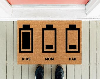 Lustige Fußmatte mit Familienbatterien: Energiegeladene Kinder, schwache Eltern