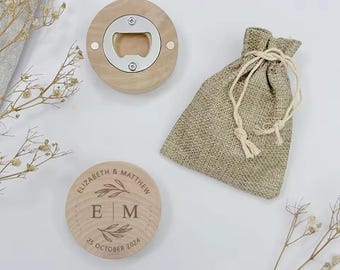 May include: A wooden bottle opener with a burlap pouch. The bottle opener is engraved with the text "Elizabeth & Matthew" and the initials "E|M" with a floral design. The date "25 October 2024" is also engraved on the bottle opener.
